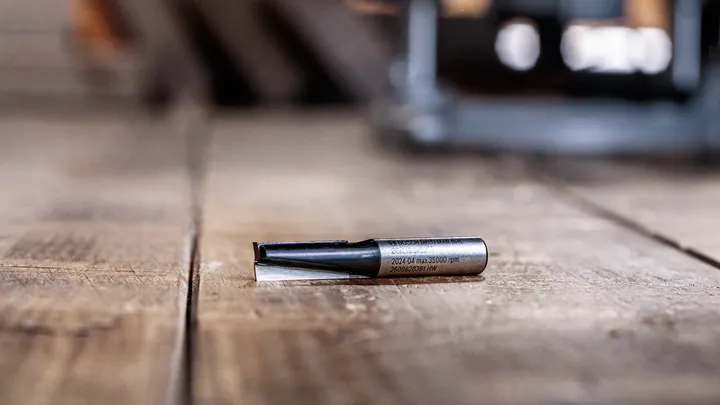 Fresa appoggiata su una superficie di legno in un'officina.