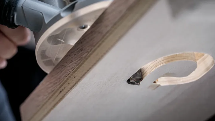 Una fresatrice per legno realizza un foro circolare preciso in una tavola di legno.