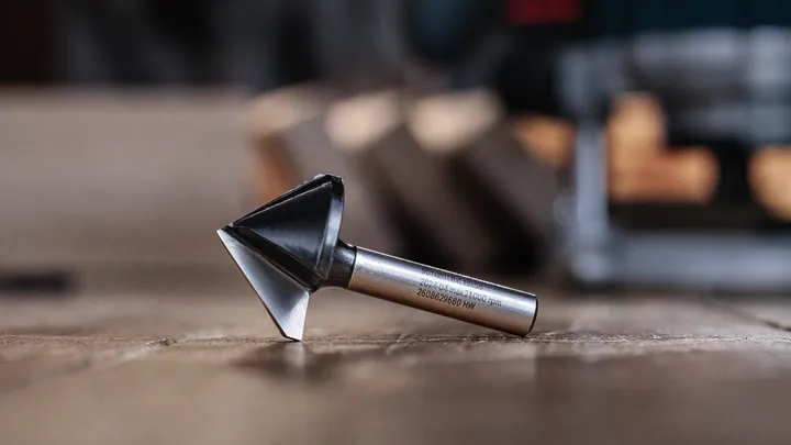 Fresa per smussi appoggiata su una superficie di legno in un'officina.