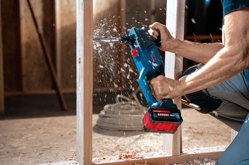 Persona che fora una struttura in legno con un trapano angolare a batteria.