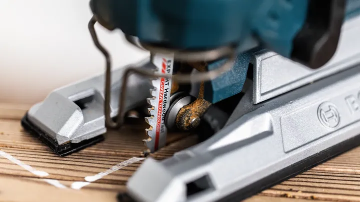 Taglio con il seghetto alternativo lungo una linea tracciata su una tavola di legno.