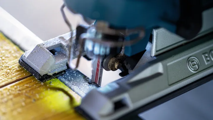 Taglio con sega circolare su una tavola di legno, producendo segatura fine.