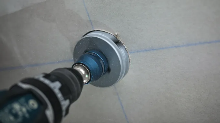 Con una sega a tazza si pratica un'apertura circolare in una parete in cartongesso.