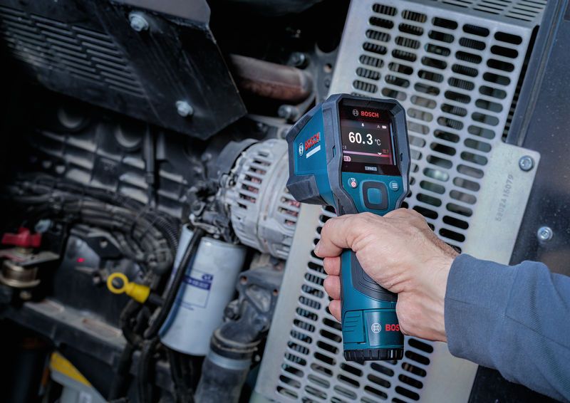 Una persona utilizza un rilevatore di temperatura per misurare la temperatura dei macchinari industriali.