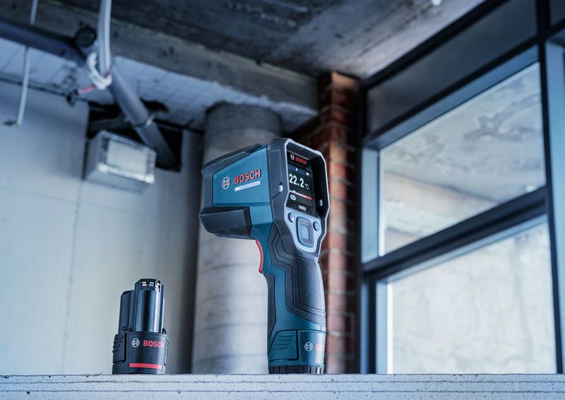 Termorilevatore e batteria posizionati su una superficie di cemento in un cantiere.