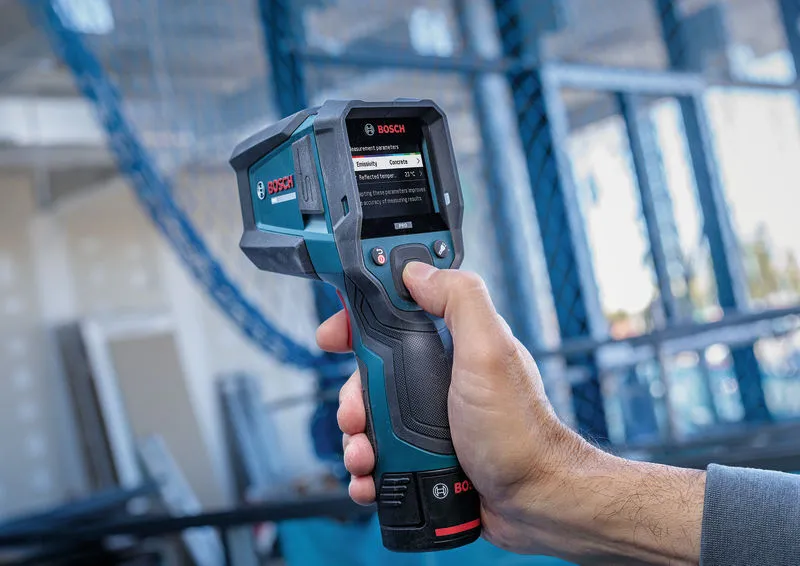 Persona che utilizza un termorilevatore portatile per misurare la temperatura superficiale in ambienti interni.