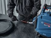 Una persona che indossa dispositivi di protezione individuale inserisce un filo in una macchina tiracavi.