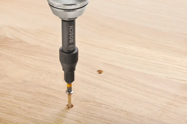 Taladro atornillador haciendo un agujero en una superficie de madera.