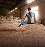 Trabajador soplando virutas de madera.