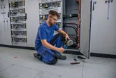 Una persona que usa equipo de seguridad engarza un cable utilizando una herramienta hidráulica inalámbrica.