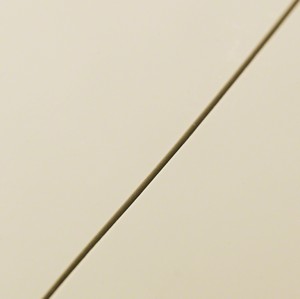 Detail rovné linie řezu na hladké béžové dlaždici.