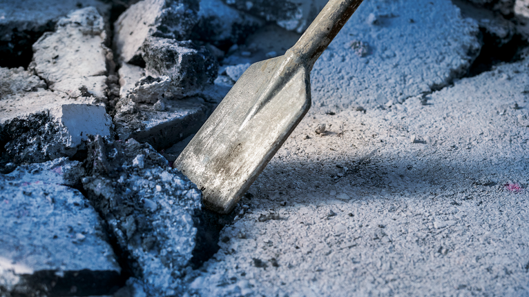 Dláto rozbíjející beton na staveništi.