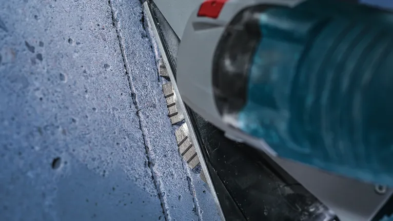 Diamantový kotouč řeže rovnou drážku do betonového povrchu.