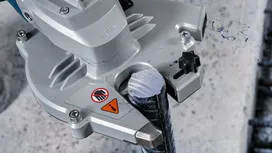Elektrické nářadí řezající kovovou výztuž na betonovém povrchu.