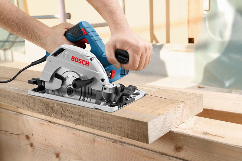 Eine Person führt eine Handkreissäge, um ein Holzbrett zu schneiden.