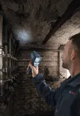 Eine Person benutzt ein Wärmebildgerät, um eine Kellerdecke zu untersuchen.