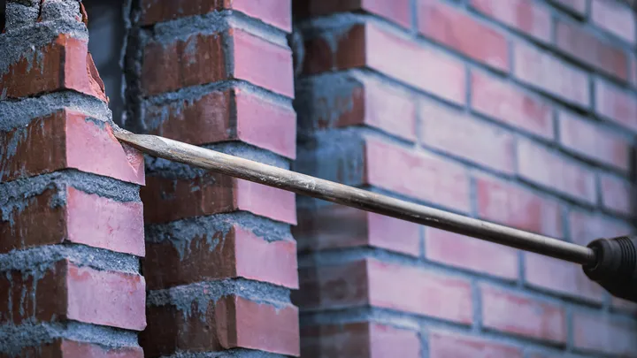 Bohrer, der ein Loch durch eine Ziegelwand bohrt.