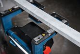 Eine kabellose Baustellenleuchte beleuchtet einen Arbeitsbereich unter einem Metallträger.