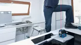 Lasernivelleringsværktøj med synlige knapper og linse på et blåt og sort hus.