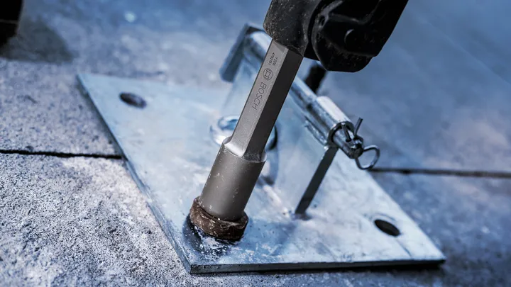 Elværktøj strammer en stor bolt ind i en metalplade.