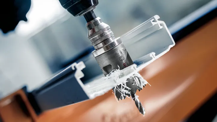 Hulsavklinge borer gennem en hvid plastkanal og producerer spåner.