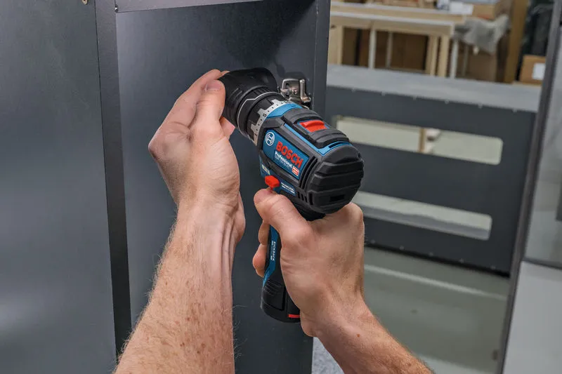 En person bruger en batteridrevet skruetrækker til at skru en skrue ind i et metalpanel.