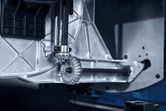 Nærbillede af et justeringsgear til en bordrundsav inde i et metalhus.
