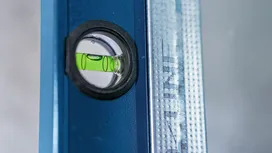 Vaterpasboble centreret på en blå metallineal.