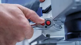 Person adjusts a metal tool with a ratchet mechanism.