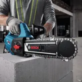 Une personne portant un équipement de sécurité coupe un bloc de béton avec un coupe-bloc AAC.