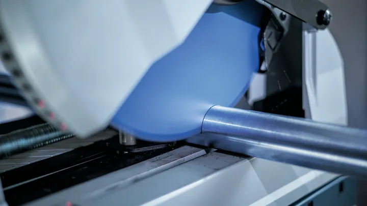Lame de scie circulaire coupant un tube métallique dans un atelier.