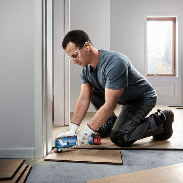 La cortadora múltiple inalámbrica Bosch GOP 185-LI recorta tablas de piso.