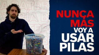 Hombre con cabello rizado al lado de un recipiente lleno de pilas, fondo azul.