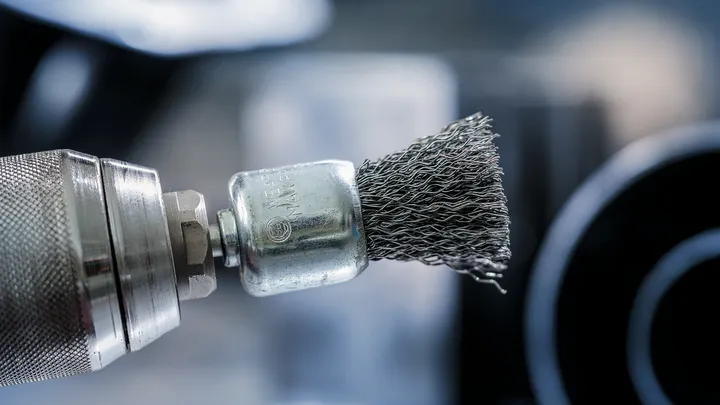 Pinna puhastamiseks kasutatav pöörlev tööriist metalltraadist harjaotsaku abil.