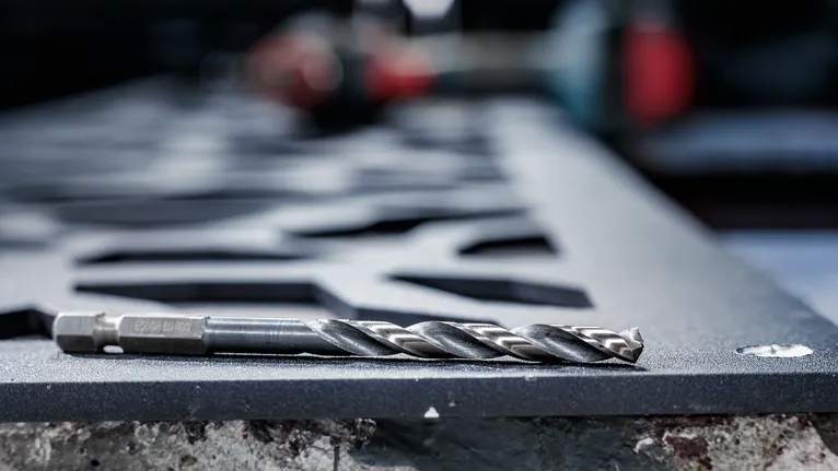 Lõigatud teraslehele asetatud metallipuur töökojas.