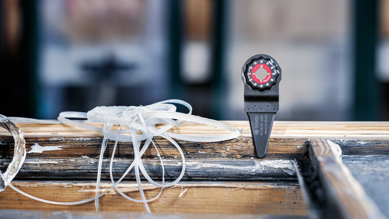 Võnkuv multitööriista terakinnitus ilmastikukindlale puidust aknaraamile.