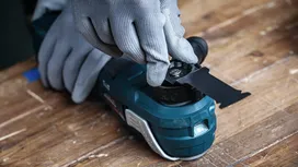 Turvavarustust kandev inimene kinnitab saetera elektrilise tööriista külge.