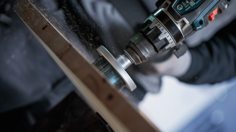 Turvavarustust kandev inimene lihvib metalli, tekitades sädemeid.