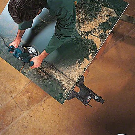 Töötaja töötab mootorsaega puitlehe lõikamiseks.