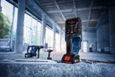 Detector de pared colocado sobre una superficie de hormigón en una obra en construcción.