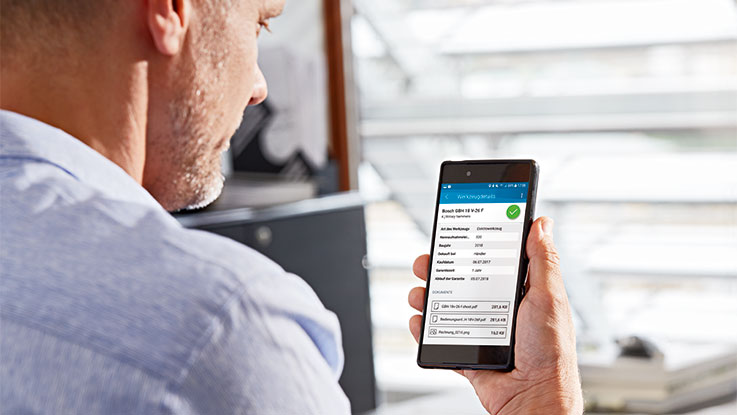 Hombre revisando información en un teléfono sobre herramientas Bosch.