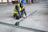 Turvavarusteita käyttävä henkilö kohdistaa säteitä laservaaituslaitteella.