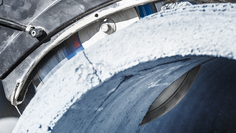 Lame de scie diamantée coupant un tuyau en béton épais.