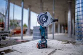 Meuleuse d'angle sans fil debout sur une surface en béton sur un chantier de construction.
