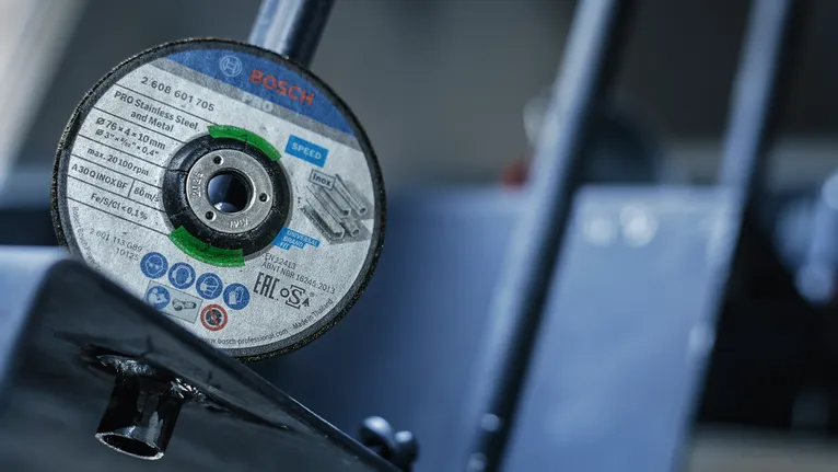 Gros plan d'un disque de coupe monté sur un outil métallique dans un atelier.