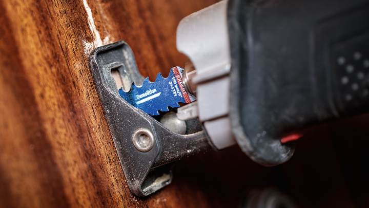 Outil multifonction oscillant avec lame de démolition coupant le bois.