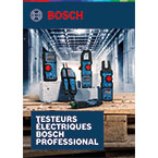 Trois testeurs électriques Bosch Professional sur une palette en bois dans un entrepôt.