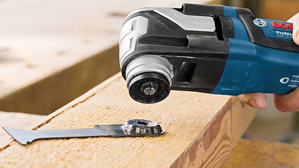 Une outil Bosch Professional bleu sur une planche de bois, avec une lame à côté.