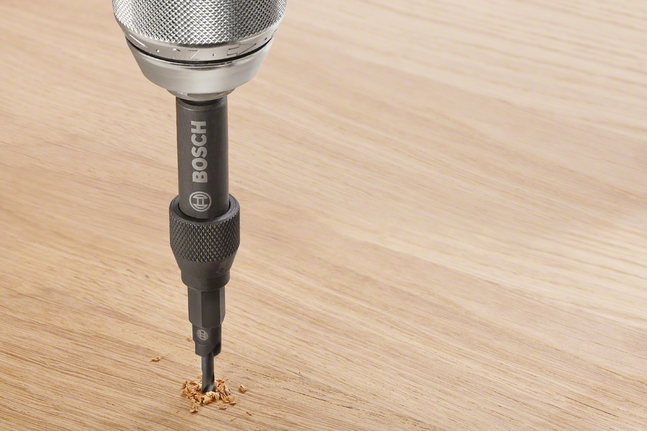 Drill bit making a precise hole in a wooden surface.