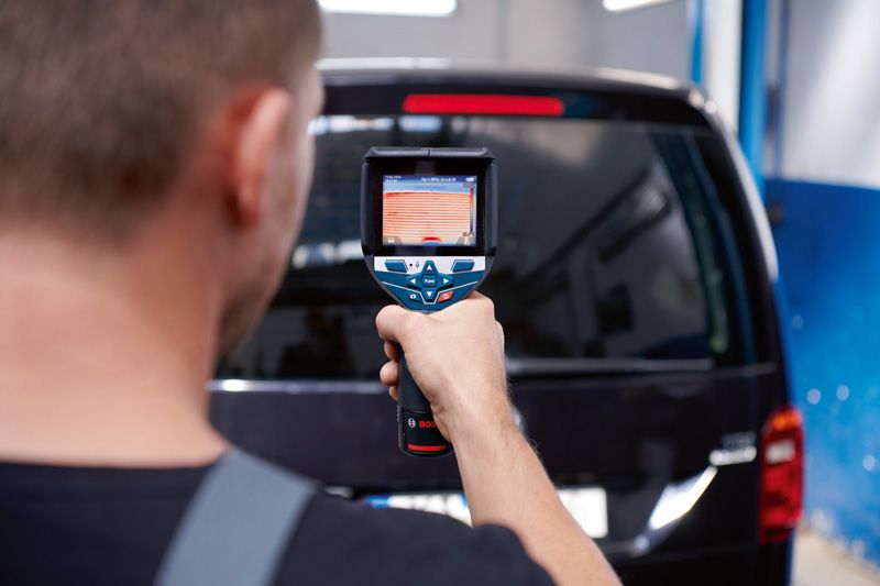 Person uses a thermo camera to scan the rear window of a vehicle.
